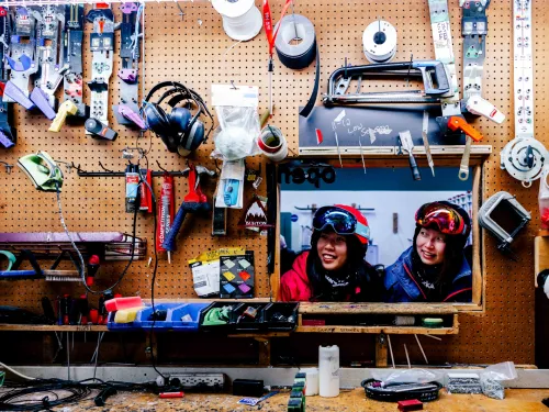 Two skiers peek inside the tech shop at Nakiska Ski Area